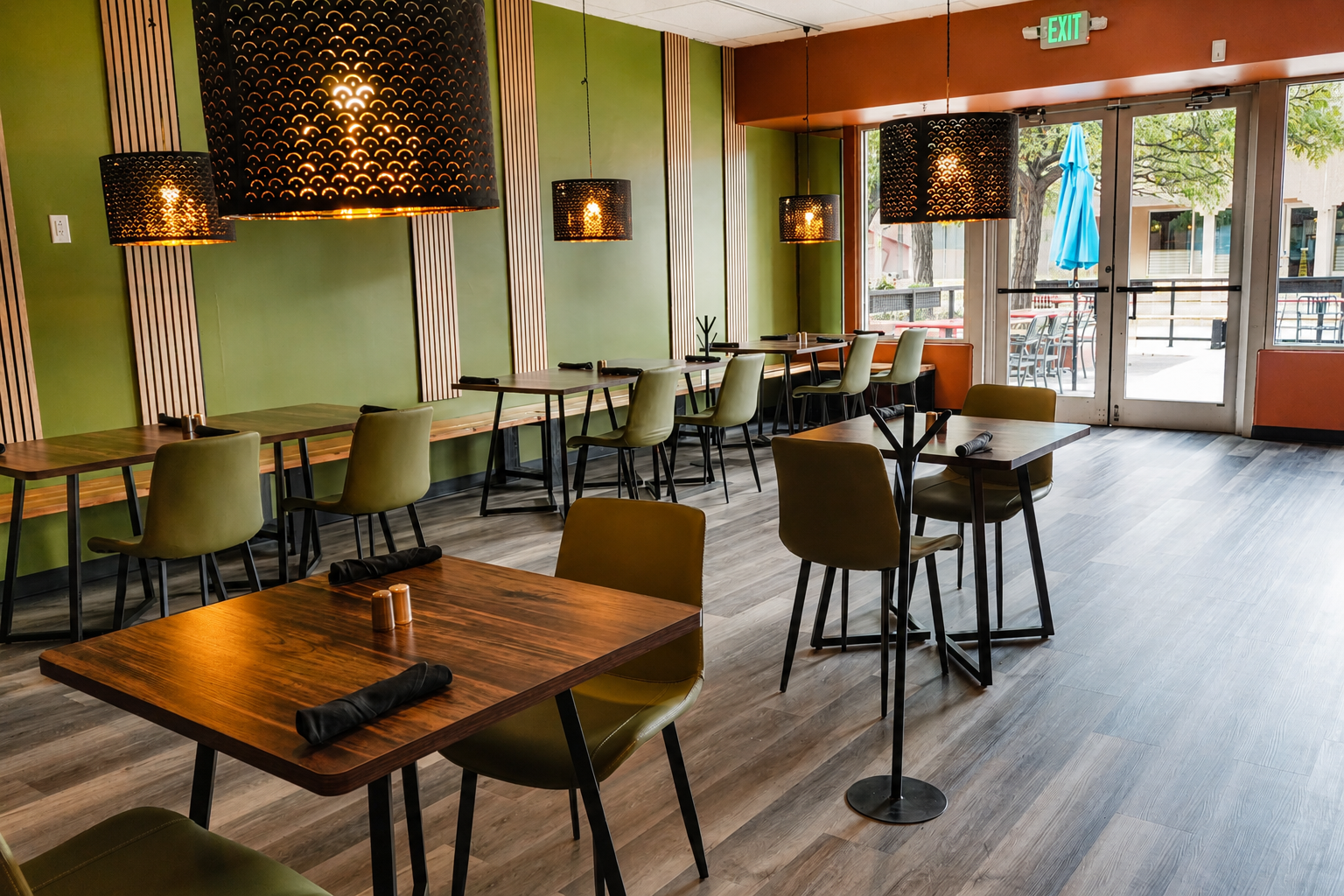 Green dining room with wooden tables and woven pendant lights