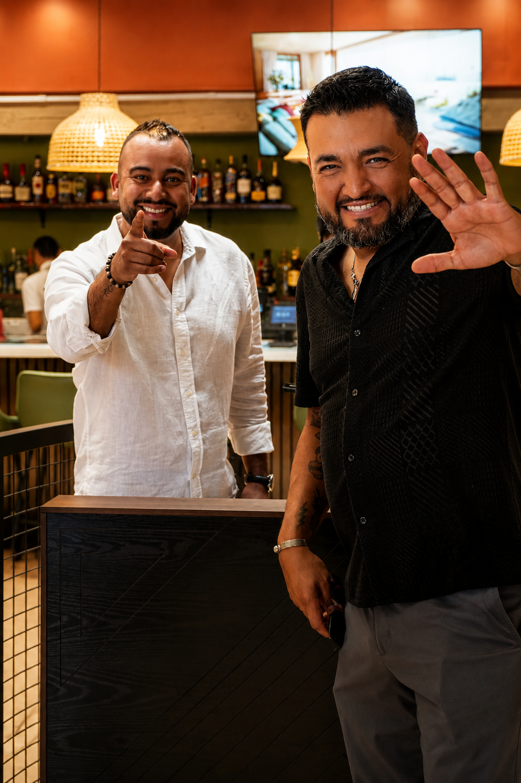 Two hosts welcoming guests at the bar